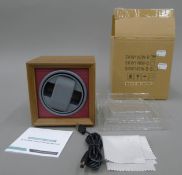 A boxed watch winder.