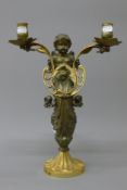 A 19th century bronze twin branch candelabra formed as a cherub. 38 cm high.