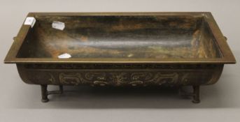 A 19th century rectangular bronze planter with archaic Chinese motifs, supported on four legs,