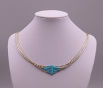 A sterling silver and turquoise necklace, and earrings. The necklace approximately 66 cm long.