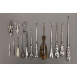 A collection of silver and other button hooks, a teddy bear rattle, etc.