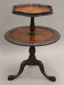 A carved walnut two-tier table. 82 cm high.