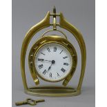 A Victorian brass horse shoe and stirrup form clock. 21.5 cm high.