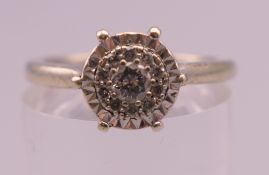 A 9 ct white gold diamond cluster ring. Ring size M. 3.1 grammes total weight.