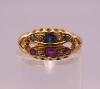 An 18 ct gold diamond, ruby and sapphire ring. Ring size O. 3.1 grammes total weight.