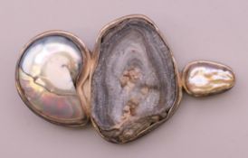 A silver abstract mother-of-pearl, nautilus shell and mineral set pendant/brooch. 8.5 cm long.