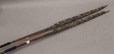 Two tribal painted wooden spears. The largest 176 cm long.