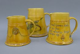 Three graduated Arts & Crafts pottery jugs, each stamped 'Made for Liberty & Co'.