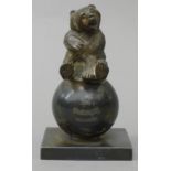 A silver plated inkwell formed as a bear on a ball, inscribed 'With Compliments W.T & H. Miller's'.