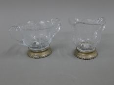 A sterling silver mounted glass sugar bowl and cream jug. The former 15.5 cm wide.