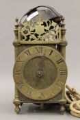 An antique lantern clock. Approximately 33 cm high.