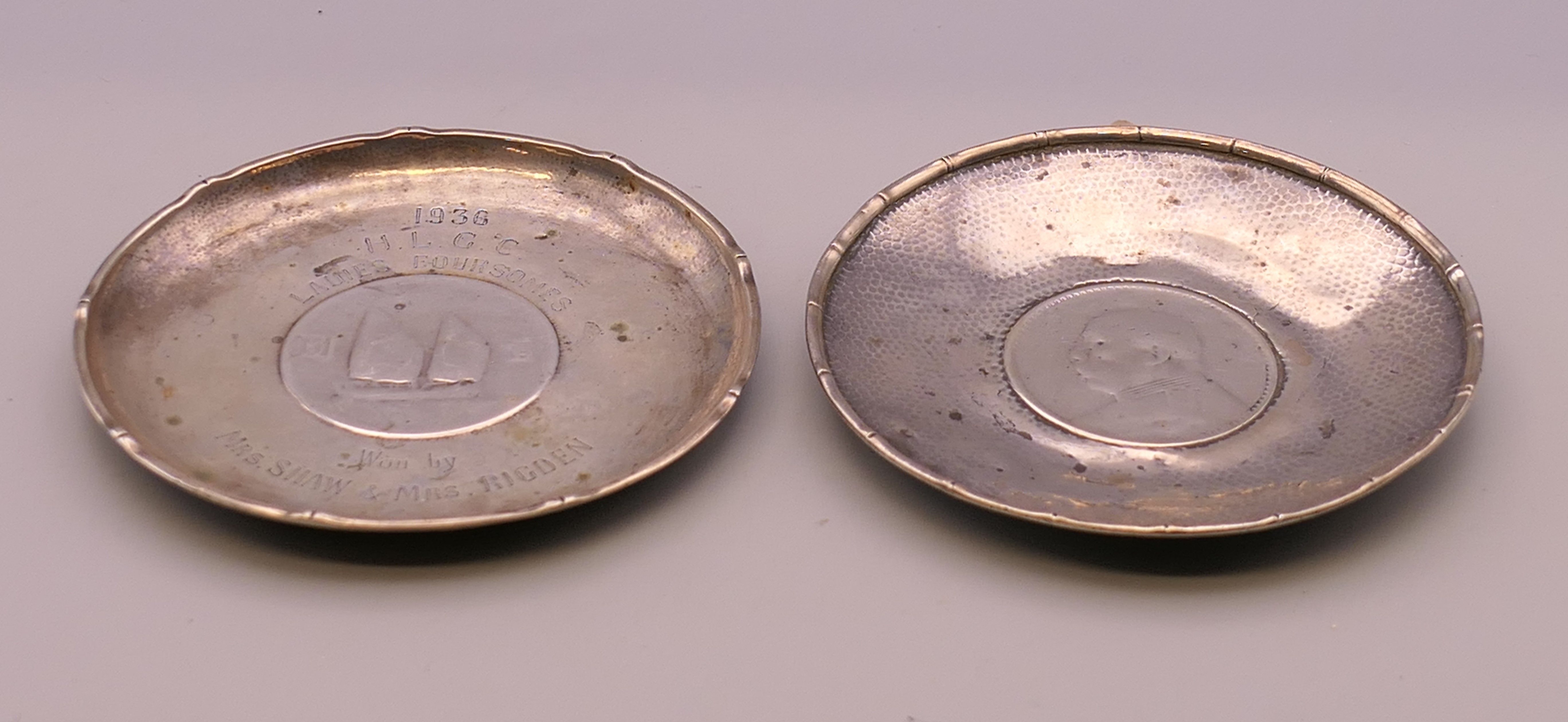 Two Chinese silver dishes inset with coins. 9.5 cm diameter. 117.9 grammes total weight.
