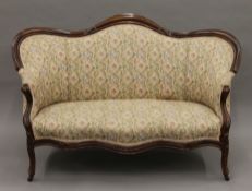 A Victorian mahogany framed two seater sofa. Approximately 135 cm long.