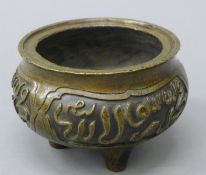 A Chinese bronze censer with panels of Middle Eastern script, the body supported by three legs.