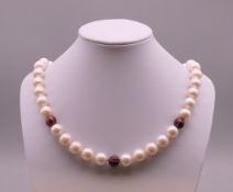 A diamond section and pearl necklace with an 18 ct white gold clasp. Approximately 46 cm long.