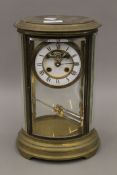 A Victorian brass cased oval four glass clock. 31 cm high.