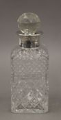 A silver collared cut glass decanter. 23 cm high.