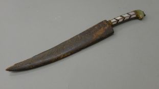 A mother-of-pearl handled dagger in leather sheath. 30.5 cm long.