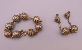 An Eastern enamel decorated bracelet and earrings. The bracelet 19 cm long.