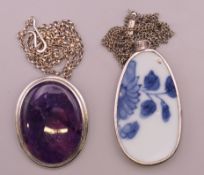 Two silver framed pendants. The largest 6 cm high.