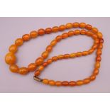 An amber bead necklace. Approximately 84 cm long. 79.2 grammes total weight.