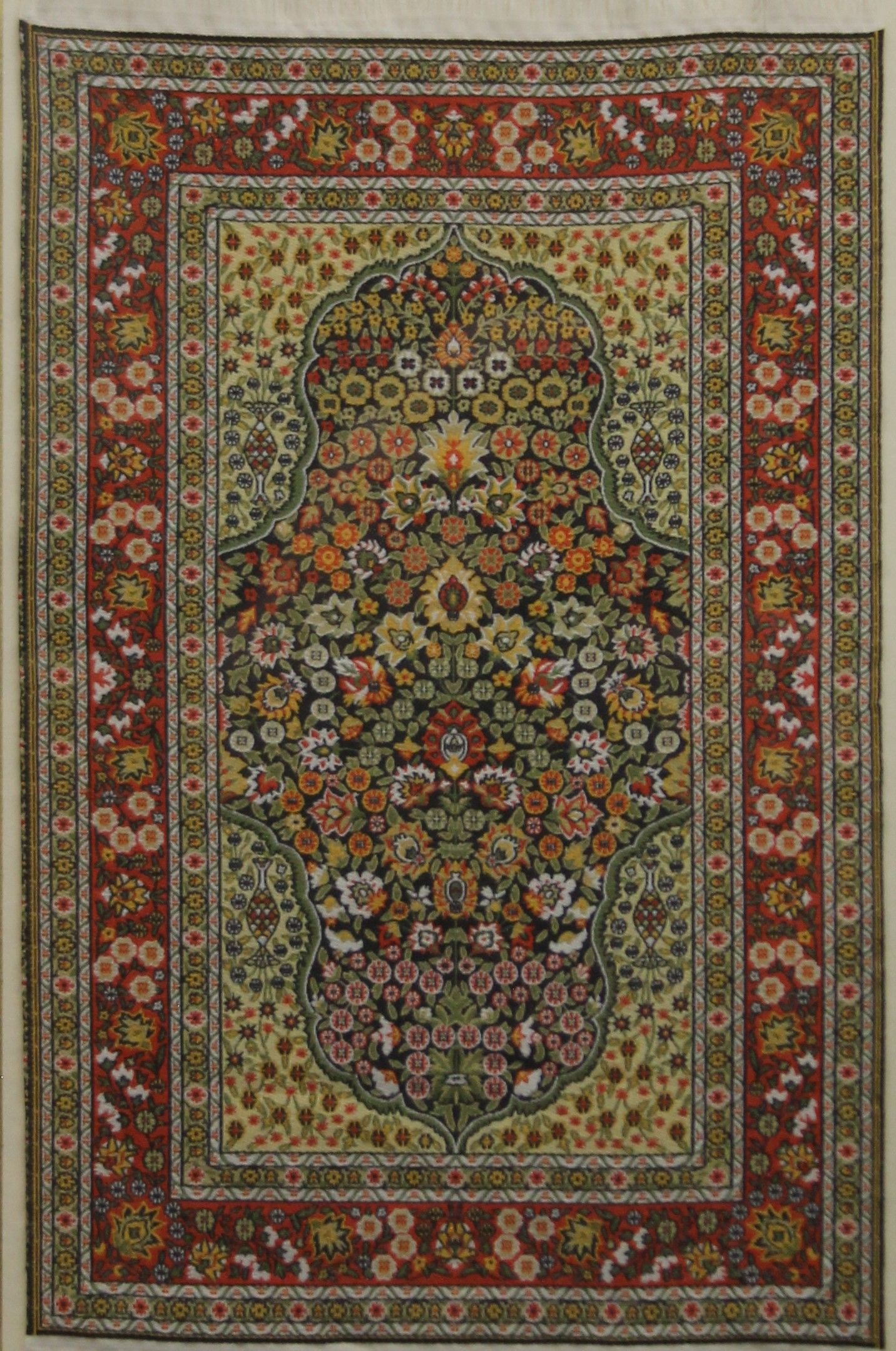 A framed and glazed miniature carpet. 28 x 38.5 cm overall.