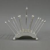 A Christopher Dresser style toast rack. 17 cm high.