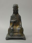 A Chinese bronze figure of a seated dignitary, with traces of gilding. 24 cm high.