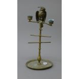 A Victorian brass stand surmounted with a parrot form vesta flanked by twin candle sconces.