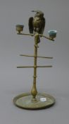 A Victorian brass stand surmounted with a parrot form vesta flanked by twin candle sconces.
