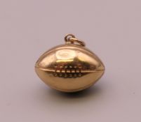 A 9 ct gold rugby ball form charm. 1.5 cm long. 0.7 grammes.
