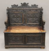 A Victorian carved oak settle. 105 cm wide.