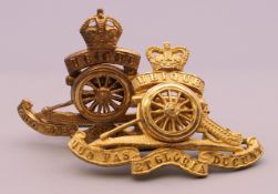 Two Royal Artillery cap badges.