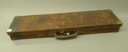 A leather brass cornered gun case. 83 cm wide.