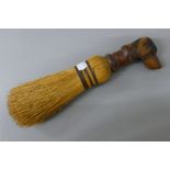 A brush mounted with a carved wooden dog's head handle. 27.5 cm high.