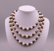 A tigers eye and pearl necklace. Approximately 116 cm long.