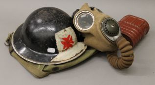 A WWII First Aid helmet and a gas mask.