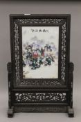 A framed Chinese porcelain table screen. 67 cm high.
