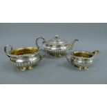 A George III three-piece silver tea set. The teapot 28 cm long. 44.3 troy ounces total weight.