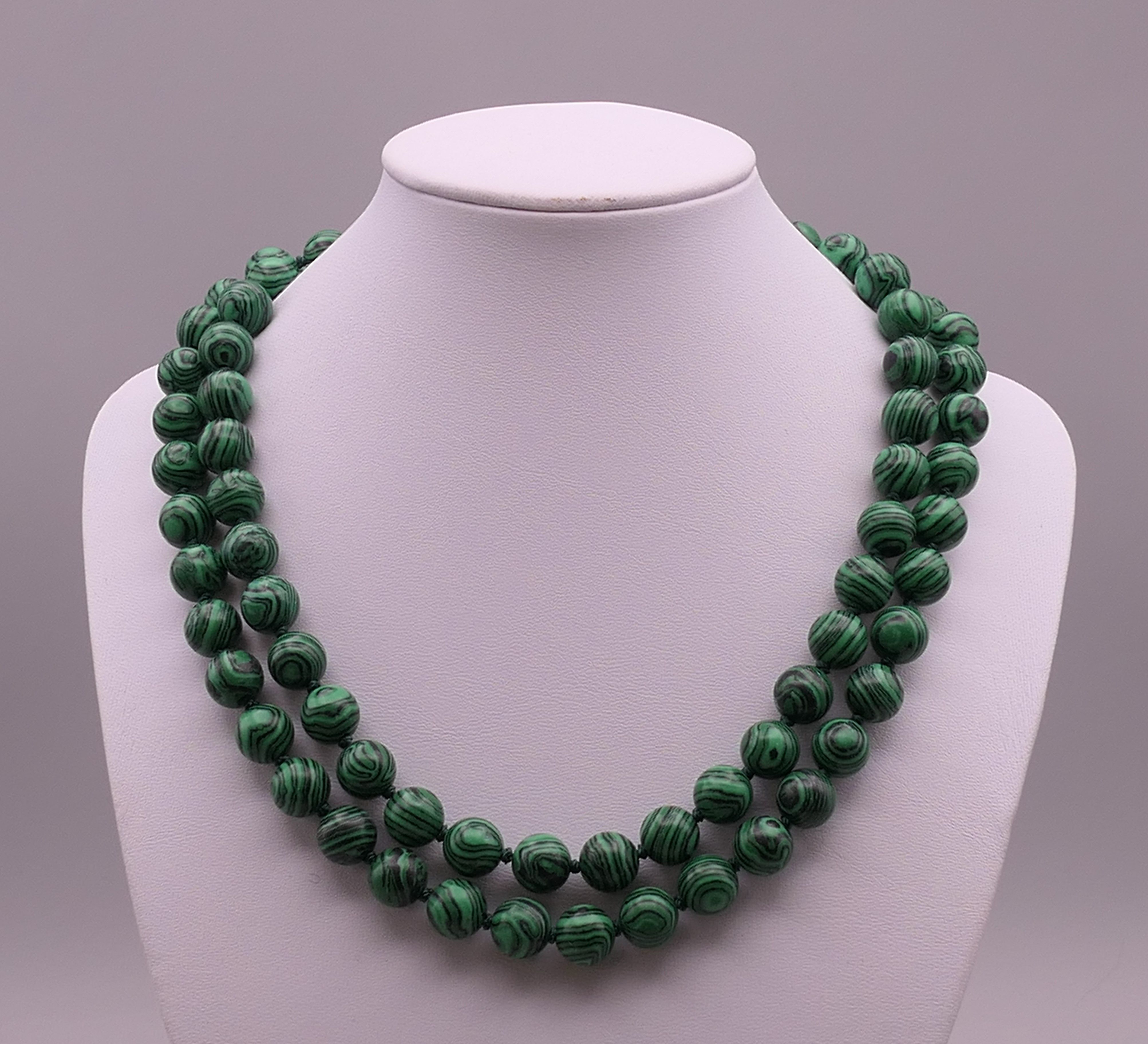 A malachite bead necklace. Approximately 88 cm long.