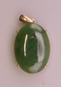 A 9 ct gold jade pendant. 3.25 cm high. 5.5 grammes total weight.