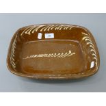 A 19th century brown and white slipware dish of rectangular form. 32 cm long.