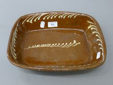 A 19th century brown and white slipware dish of rectangular form. 32 cm long.