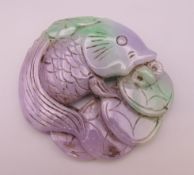 A lilac jade carving formed as a fish and money. 8 cm wide.