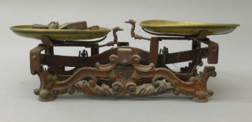 A set of ornate Victorian cast iron and brass scales with various weights, etc. 55.5 cm long.