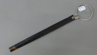 A tortoiseshell handled silver magnifying glass. 31 cm long.