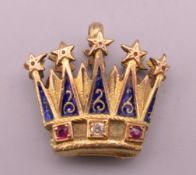 An unmarked gold, diamond, ruby and enamel crown form pendant. 2.25 cm wide x 2 cm high.