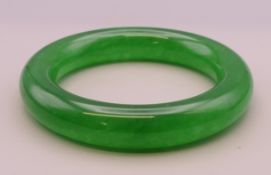 An apple green jade bangle. Interior diameter approximately 6 cm.
