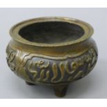 A Chinese bronze censer with panels of Middle Eastern script, the body supported by three legs.