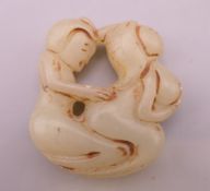 An erotic jade roundel. 5 cm high.